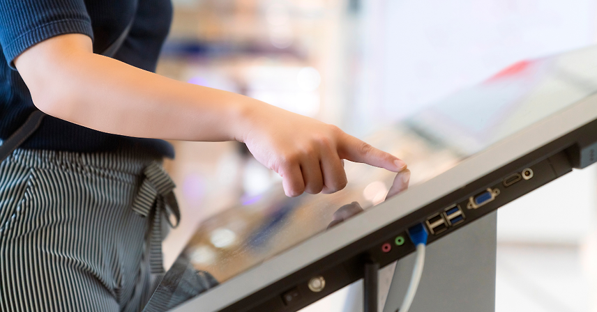A visitor using a museum's interactive touchscreen kiosk.